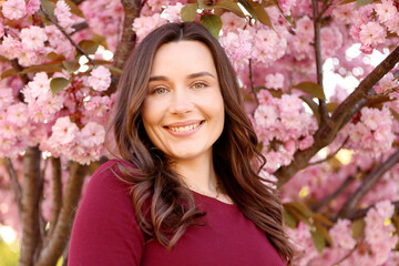 Fototapeta premium Beautiful woman near blossoming tree on spring day
