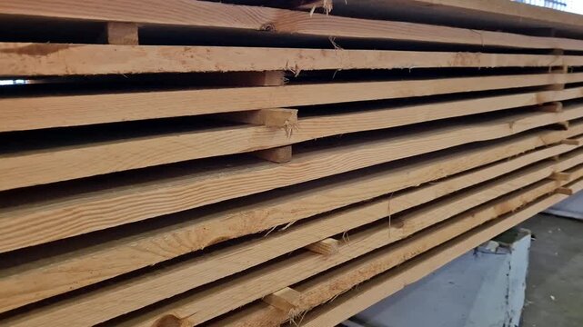 A stack of freshly sawn softwood (pine/spruce) boards stacked for storage or transportation. The wood has been pre-treated and is ready for use in construction or furniture production. Stack