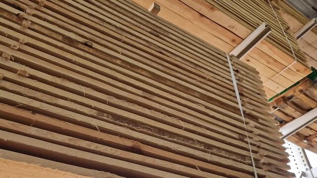 A stack of freshly sawn softwood (pine/spruce) boards stacked for storage or transportation. The wood has been pre-treated and is ready for use in construction or furniture production. Stack