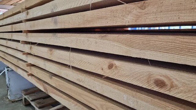 A stack of freshly sawn softwood (pine/spruce) boards stacked for storage or transportation. The wood has been pre-treated and is ready for use in construction or furniture production. Stack
