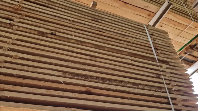 A stack of freshly sawn softwood (pine/spruce) boards stacked for storage or transportation. The wood has been pre-treated and is ready for use in construction or furniture production. Stack