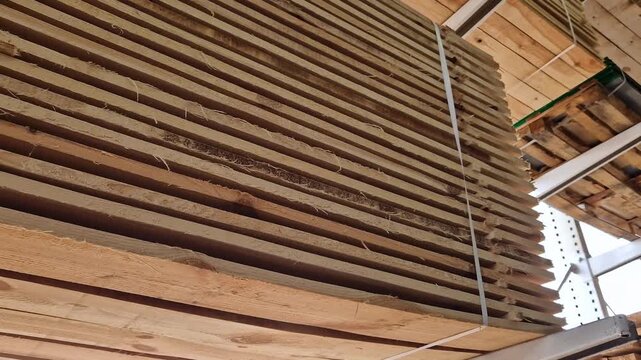 A stack of freshly sawn softwood (pine/spruce) boards stacked for storage or transportation. The wood has been pre-treated and is ready for use in construction or furniture production. Stack
