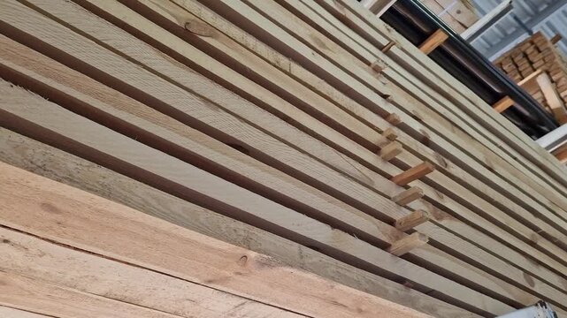 A stack of freshly sawn softwood (pine/spruce) boards stacked for storage or transportation. The wood has been pre-treated and is ready for use in construction or furniture production. Stack