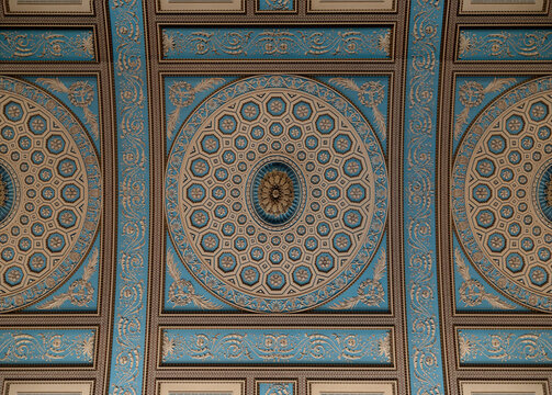 A symmetrical view highlights the breathtaking intricacy of the ornate classical ceiling within the Chapel of St Peter & St Paul.At its center lies a grand oval medallion, heavily decorated with sculp