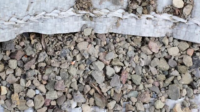 Macro close up, selective focus background image of small gravel rocks, soft focus, video zooming out hand held