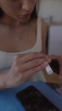 Female individual disinfects phone with cotton swab meticulously