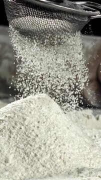 The flour is sifted onto a mound with flour. Filmed on a high-speed camera at 1000 fps. High quality FullHD footage