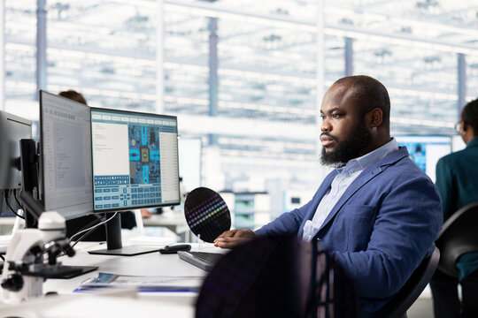 Engineer designing cutting edge SoC architecture in hardware manufacturing facility office. Microchip designer creating microelectronics components for computers in industry plant workplace