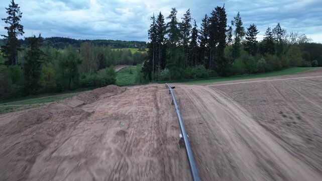 New gas pipeline construction with pipes and earthworks before burial aerial view