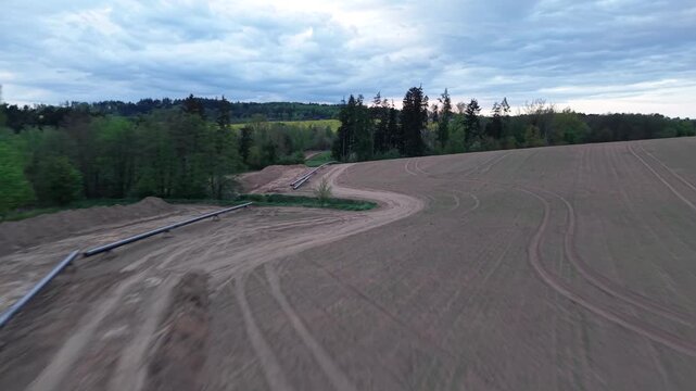 New gas pipeline construction with pipes and earthworks before burial aerial view