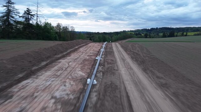 New gas pipeline construction with pipes and earthworks before burial aerial view