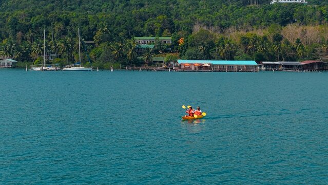 People kayaking on turquoise sea exploring koh chang island coastline