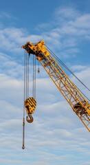 Naklejka premium Yellow Crane Against a Cloudy Blue Sky.