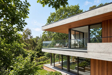 Fototapeta premium Modern architectural house exterior with wood cladding and glass balcony