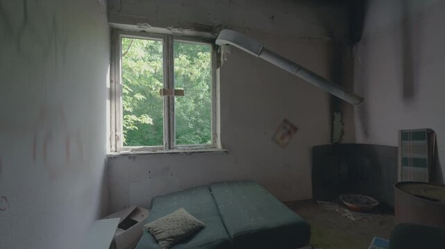 Abandoned Room with Old Sofa Pillow Burned Ceiling Push-In Shot | Ventilation Pipe Debris Dirty Walls Window with Green Trees | Derelict Living Space Urban Exploration Wide Angle View