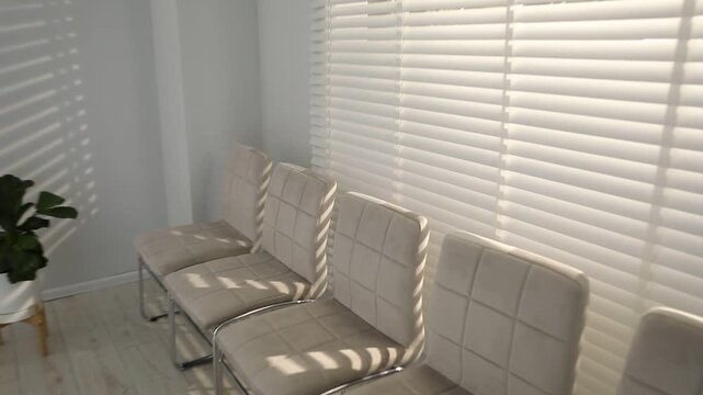 Many stylish chairs near window in office. Camera moving down and zooming out