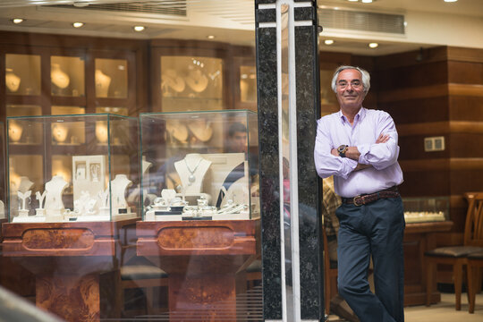 Middle Eastern jewelry shop owner standing by display as couple shops for wedding rings with family