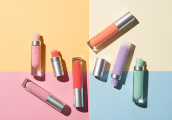 Obraz premium Colorful lip gloss tubes on pastel geometric background
