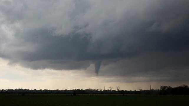 Time lapse footage of a funnel cloud extending down to the ground as a tornado forms.