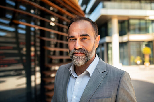 Confident bearded businessman portrait outside office