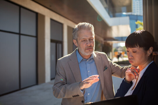 Business colleagues discussing strategy outside office building