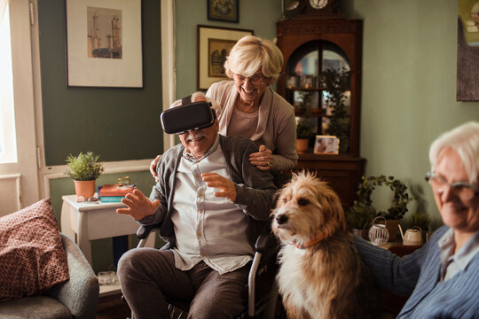 Senior man in wheelchair using virtual reality at home