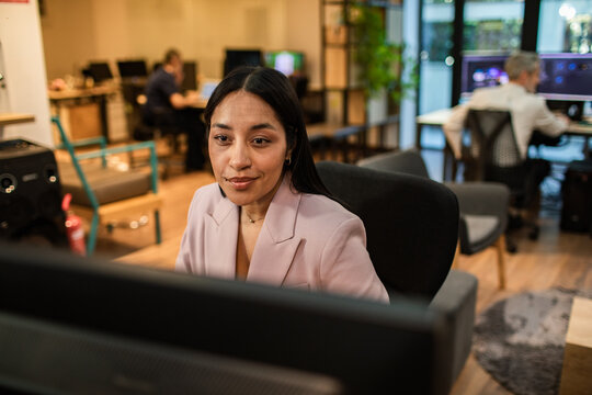 Businesswoman working at computer in modern coworking office