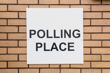 Fototapeta premium Polling place sign on brick wall close up