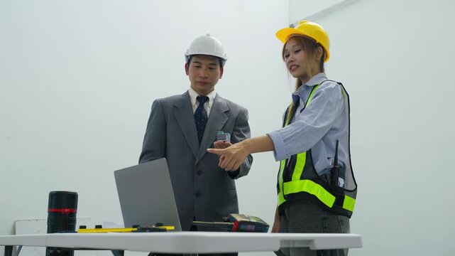 Construction planning engineer worker laptop hardhat safety vest office meeting hard hat construction meeting project collaboration indoor business hand tool helmet review discussion teamwork