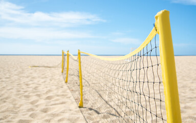 Fototapeta premium Close up of Bright Yellow Volleyball Net Stretched on Sandy Beach