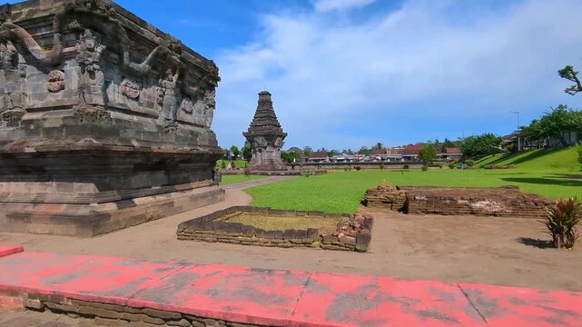 Ruins of Penataran Temple in Blitar, East Java, Indonesia with a clear blue sky and green grassland as a backdrop.
