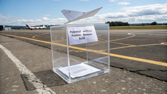 Paper plane concept in clear acrylic box on runway