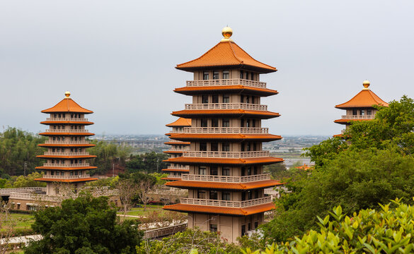 Fo Guang Shan Monastery pagodas in Kaohsiung, Taiwan. Iconic multi-tiered Buddhist temple structures. Traditional Asian architecture. Spiritual and cultural landmark against cloudy sky.
