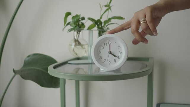 Clock on table with plants in simple room setting