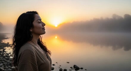 Fototapeta premium Peaceful young woman with closed eyes enjoying the misty sunrise over a calm lake, bathed in warm golden light and natural tranquility