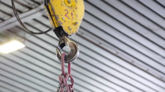 Crane beam hook moving in factory settings. Industrial crane beam with hook and cable moves across factory. metallurgical production, metal processing, heavy industry manufacturing process, 4 k video