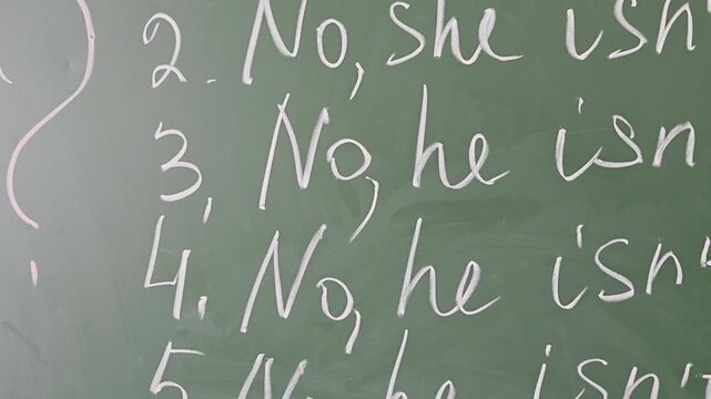 English grammar lesson handwritten on a green school chalkboard.