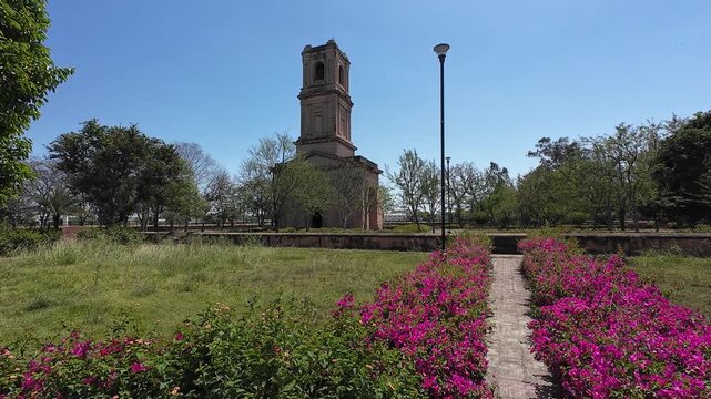 Scenic View of the Historic Cantonment Church Tower Framed by an Iron Gazebo and Vibrant Bougainvillea Flowers in Karnal
