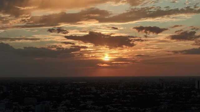 Aerial view of the golden sunset over the coastal city of Progreso and Yucalpeten with dramatic clouds and a silhouetted skyline in Progreso, Yucatan, Mexico.