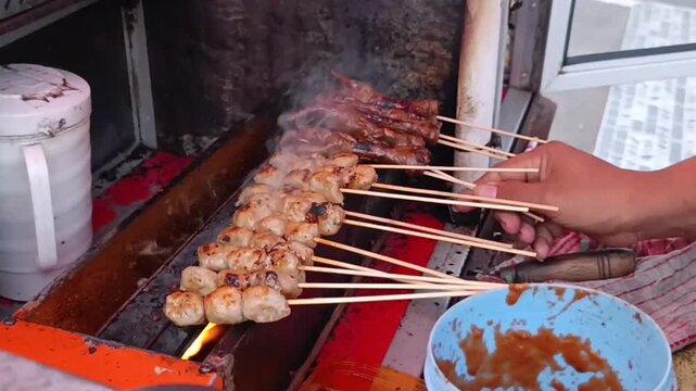 Skewered Meat Grilling on Open Flame Aiming for Smoky Delicious Flavor in Outdoor Street Kitchen