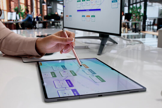 Young Woman Using Tablet To Design App With Drag