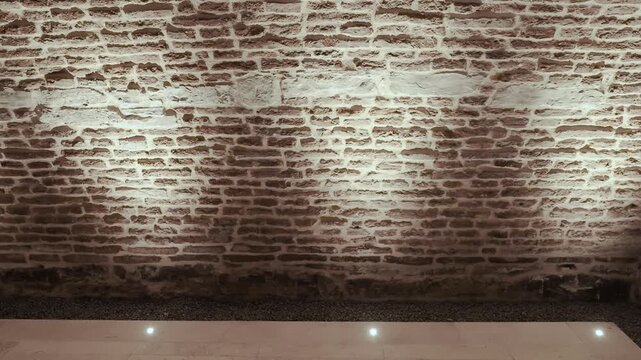 Illuminated brick wall texture exhibition space with dramatic rustic atmosphere loop video