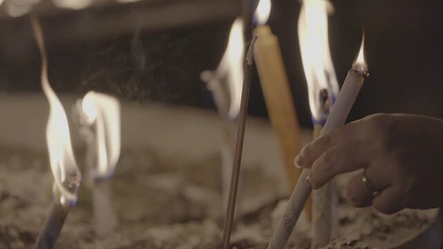 Lighting candles to worship Buddha statues in temples is a traditional Asian practice.