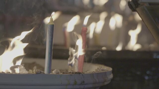 Lighting candles to worship Buddha statues in temples is a traditional Asian practice.