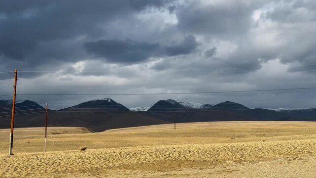 Dramatic storm clouds above arid Altai mountain steppe near Mongolia border across remote highland wilderness landscape