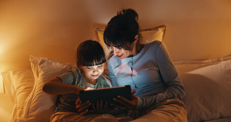 Obraz premium Night, mother and child in bed with tablet, reading ebook and bedtime story for bonding together. Evening, mom and daughter relax in home with tech, literature or kids storytelling app for fairytale.