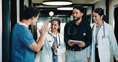 Tablet, doctors and high five in clinic for discussion, report or collaboration success. Team,...