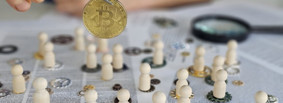 Investing in cryptocurrency with wooden figures and coins on a table