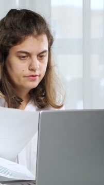 Accountant Examines Documents Diligently. Female Accountant Organizes Receipts At Her Desk. Female Accountant Carefully Sorts Through Bills And Reviews Figures At Her Organized Workspace