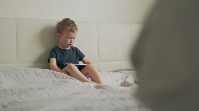 Little child playing an educational game on an iPad.